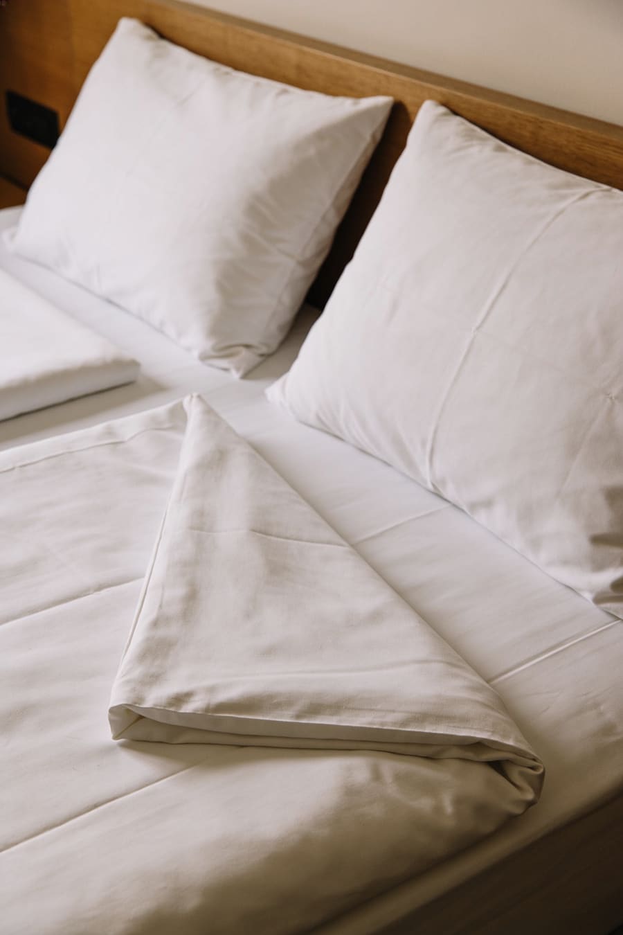 Frisch gemachtes Bett mit präzis gefalteter Duvetecke.